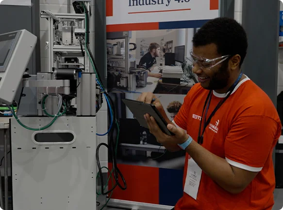Technician working beside automated production equipment